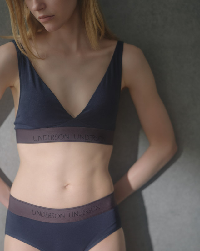 ソファに横たわっている水色のドレスを着た髪を結んだ女性