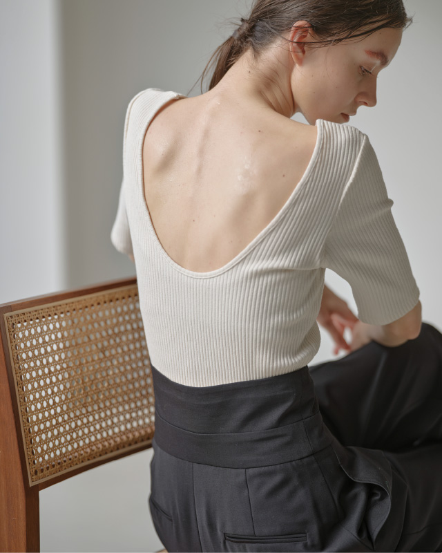 ホワイトのハーフスリーブリブトップス（カップ付き）を着用した女性