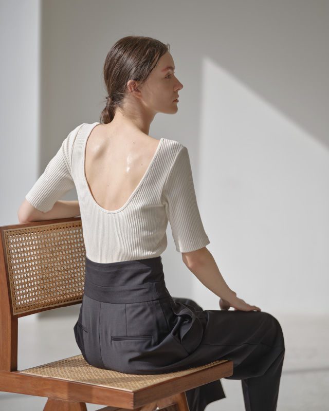 ホワイトのハーフスリーブリブトップス（カップ付き）を着用した女性