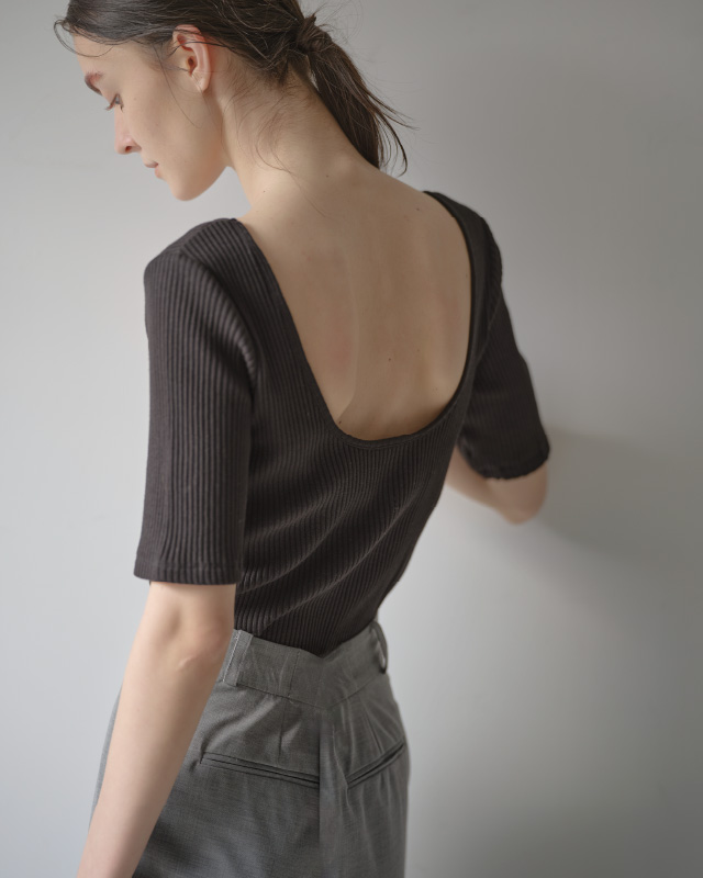 ブラックのハーフスリーブリブトップス（カップ付き）を着用した女性