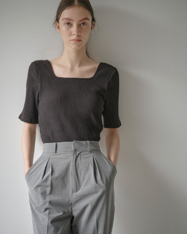 ブラックのハーフスリーブリブトップス（カップ付き）を着用した女性