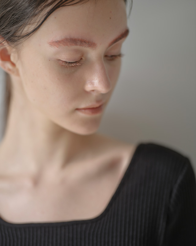 ブラックのハーフスリーブリブトップス（カップ付き）を着用した女性