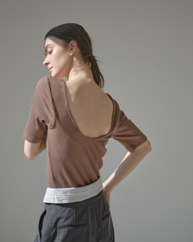 ブラウンのハーフスリーブリブトップス（カップ付き）を着用した女性